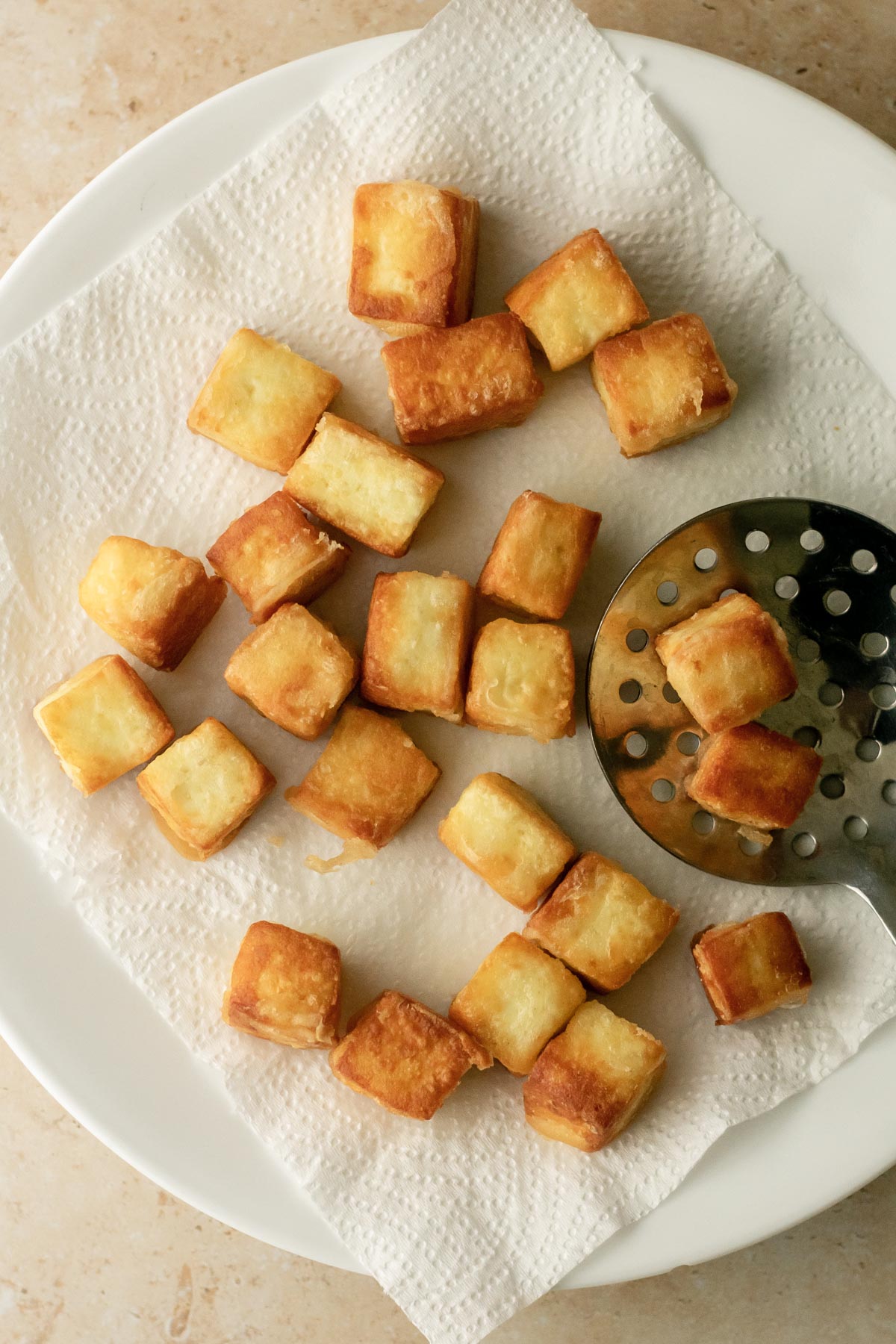 crispy fried paneer cubes on a paper towel