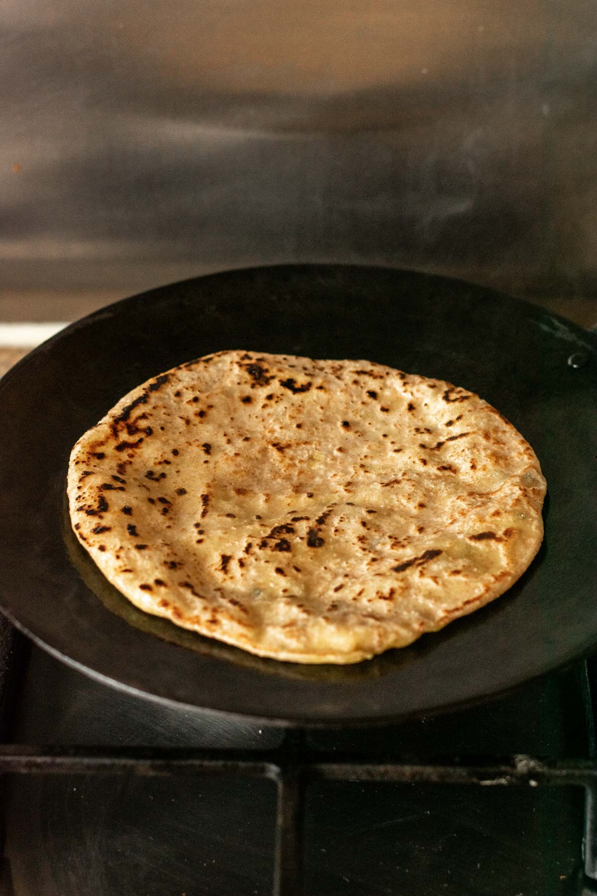 aloo paratha being cooked on a tawa