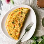 a masala omelette on a plate with a fork