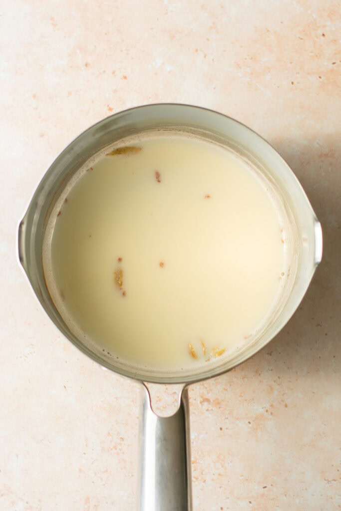 sweet saffron milk with cardamom pods in a saucepan