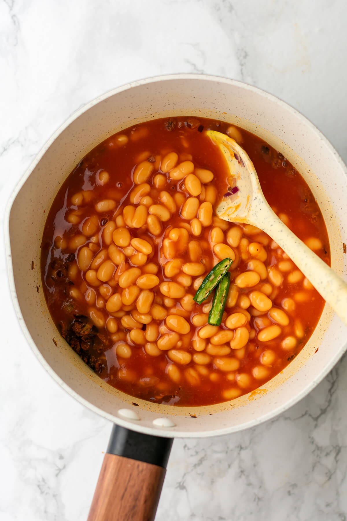 baked beans and green chili added to a mix of spiced onions