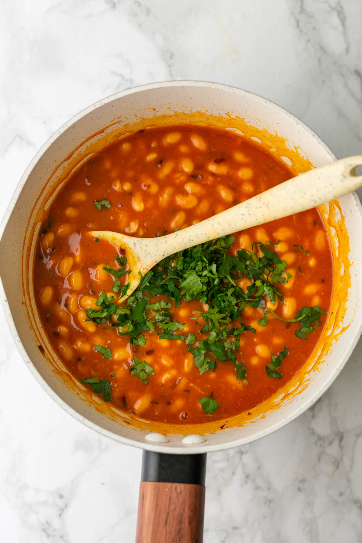 a pan of masala beans with coriander on top