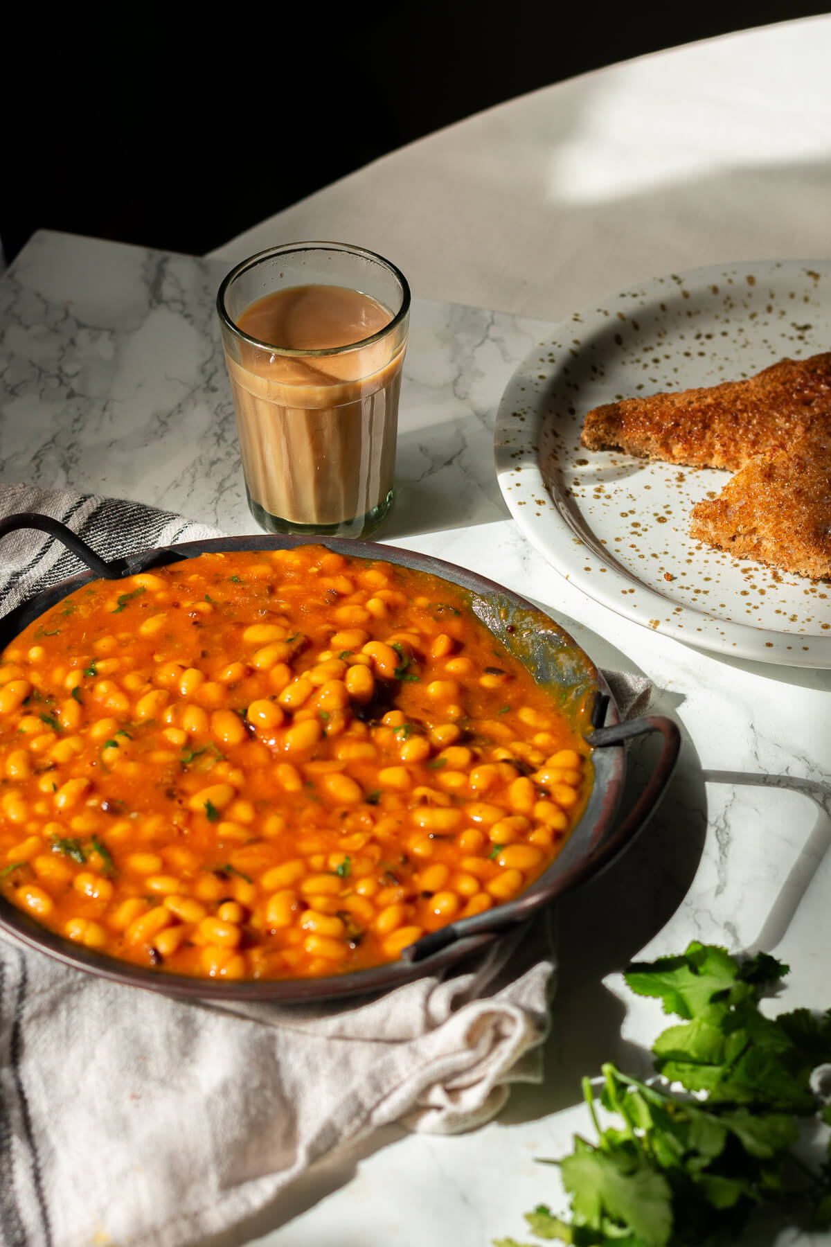 a tray of masala beans served with chai and buttery toast