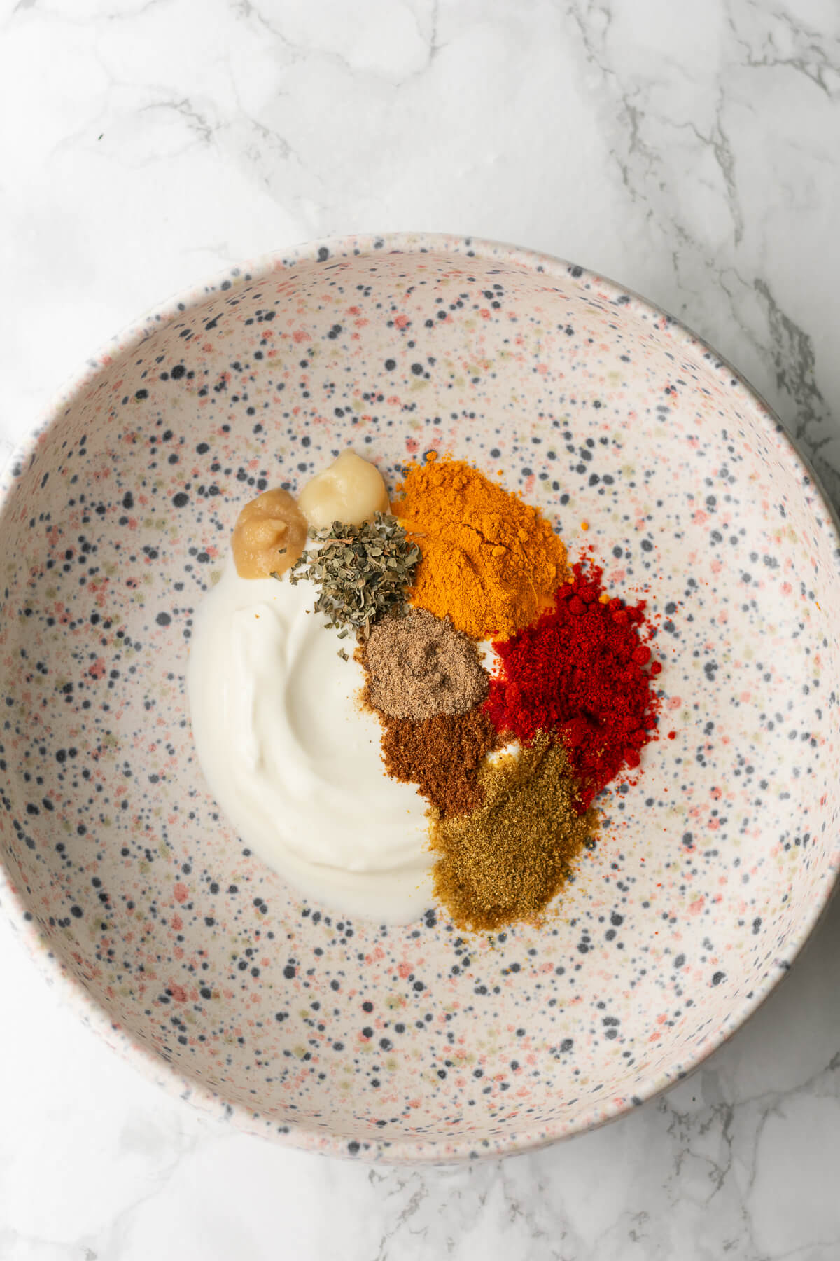 yogurt and required spices for tikka marinade in a bowl