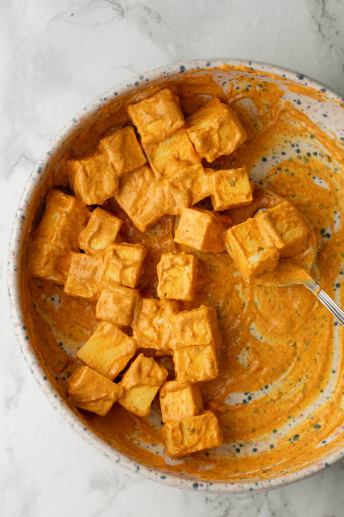 a bowl of paneer cubes mixed into tikka marinade