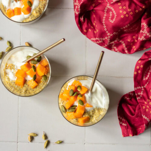 three jars of mango chia pudding with spoons