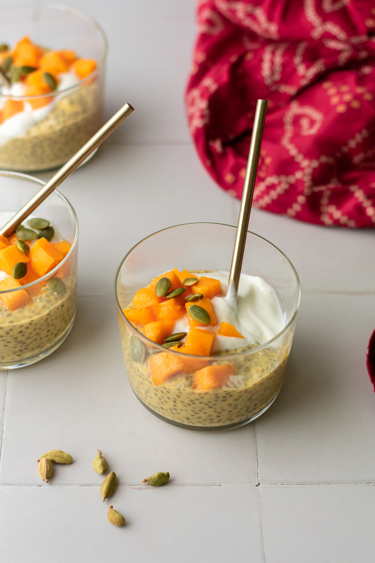 side view of mango chia pudding topped with yogurt and mango chunks