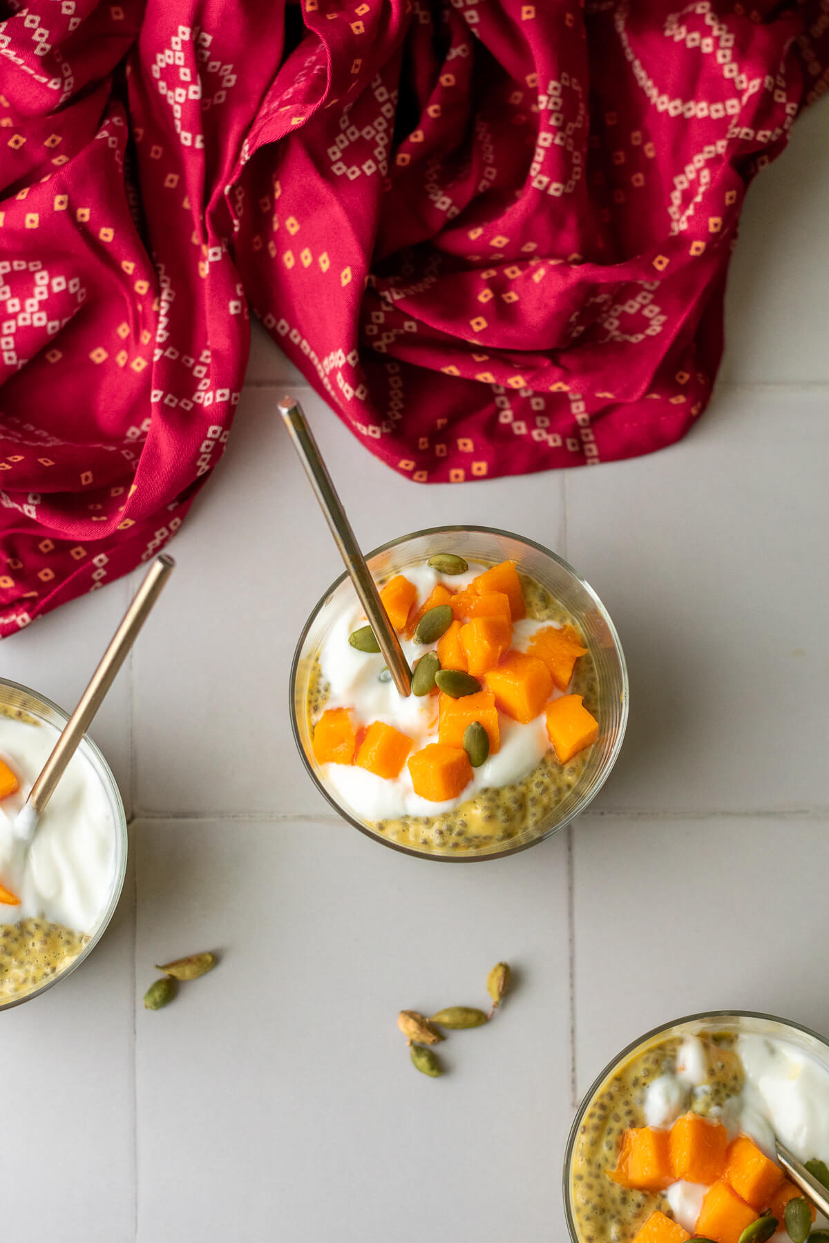 overhead shot of three jars of mango chia pudding