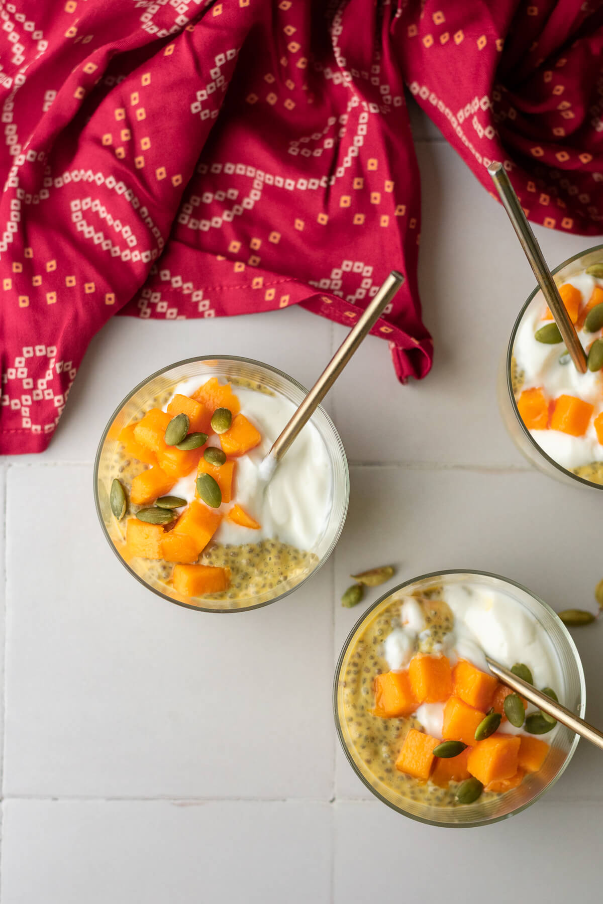 mango lassi chia pudding topped with yogurt, mango chunks and pumpkin seeds