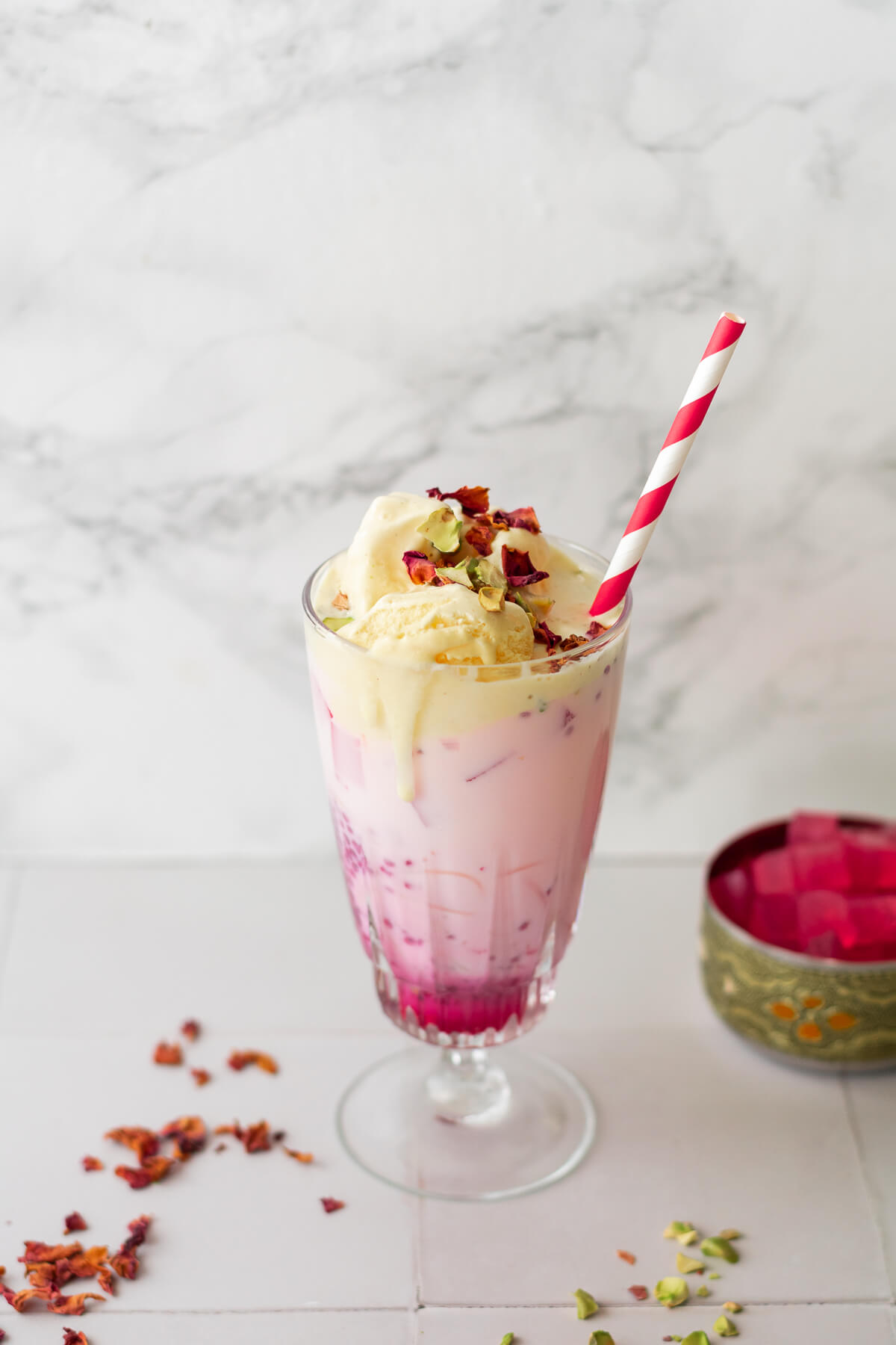 rose falooda in a milkshake glass with a scoop of ice cream on top