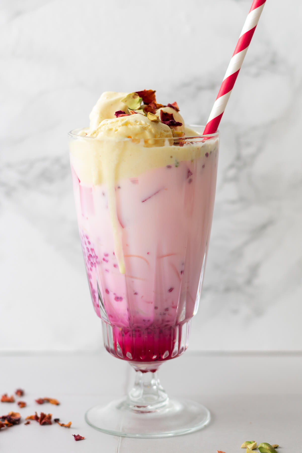 close up of a glass of falooda showing vermicelli strands and basil seeds